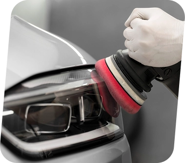 Koplampen worden gerestaureerd met behulp van een polijstmachine om het zicht te verbeteren, oxidatie te verwijderen en het uiterlijk van de auto te verbeteren.